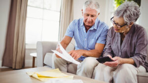 A senior couple reviews HECM documents in their home.