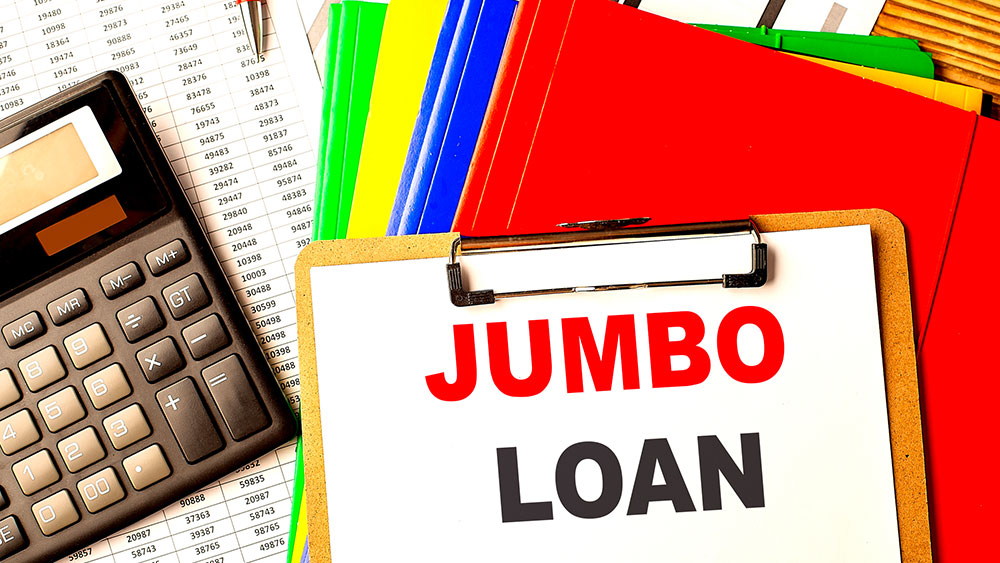 Jumbo Loan text on a clipboard with a calculator and color folders.