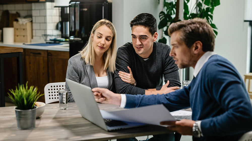 Young married couple and real estate agent going over housing options in the Tampa Bay area